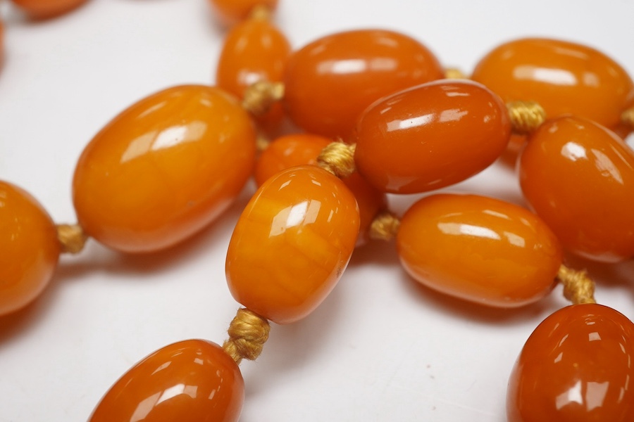 A single strand graduated oval amber bead necklace, 62cm, gross weight 34 grams. Condition - poor to fair